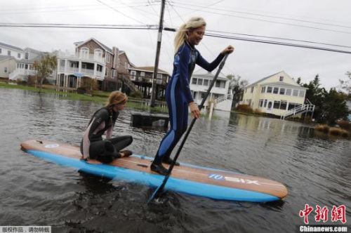 当地时间10月30日,美国特拉华州,飓风“桑迪”肆虐过后,当地遭到洪水侵袭,Jenna Webb(左)和Zoe Jurusik在街道上“滑水”。 当地时间10月30日,美国特拉华州,飓风“桑迪”肆虐过后,当地遭到洪水侵袭,Jenna Webb(左)和Zoe Jurusik在街道上“滑水”。