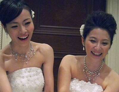 东小雪(左)和广子在婚礼上身着婚纱点蜡烛(网页截图) 东小雪(左)和广子在婚礼上身着婚纱点蜡烛(网页截图)