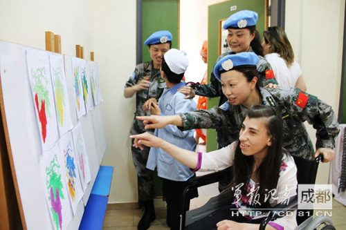 维和医疗女队员同残疾儿童一同观看孩子们的美术作品。(王强 摄) 维和医疗女队员同残疾儿童一同观看孩子们的美术作品。(王强 摄)