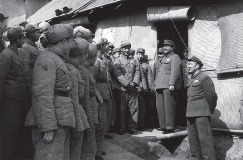 李正副司令员(右)陪同贺龙到战士们住的席棚看望 李正副司令员(右)陪同贺龙到战士们住的席棚看望