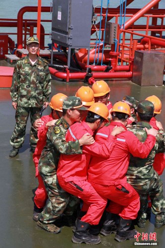 7月31日,山东省东营市边防支队的国家二级心理咨询师-王晓龙,正在渤海埕岛30A海上作业平台上组织工人们进行团体心理行为训练。梁犇 摄 7月31日,山东省东营市边防支队的国家二级心理咨询师-王晓龙,正在渤海埕岛30A海上作业平台上组织工人们进行团体心理行为训练。梁犇 摄