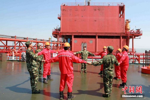 7月31日,山东省东营市边防支队的国家二级心理咨询师-王晓龙,正在渤海埕岛30A海上作业平台上组织工人们进行团体心理行为训练。 7月31日,山东省东营市边防支队的国家二级心理咨询师-王晓龙,正在渤海埕岛30A海上作业平台上组织工人们进行团体心理行为训练。