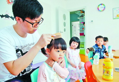 杨一林为孩子梳头。王火炎 摄 杨一林为孩子梳头。王火炎 摄