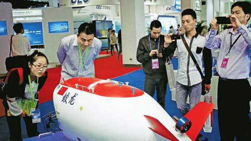 参观者纷纷在蛟龙号模型前拍照留念 参观者纷纷在蛟龙号模型前拍照留念