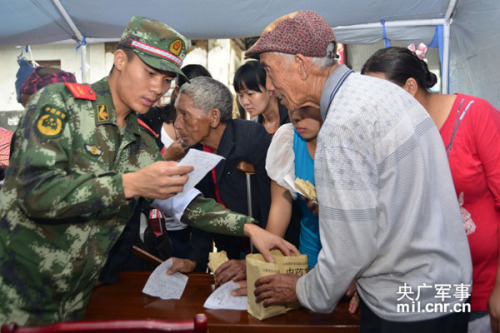 图为谢樵为灾区群众发放中药 图为谢樵为灾区群众发放中药