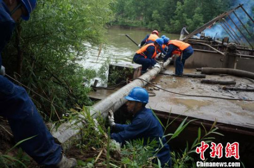 图为供电工人从船上搬运电线杆,由于小岛四面环水,材料运输全靠船只进行,非常不便。 周小云 摄 图为供电工人从船上搬运电线杆,由于小岛四面环水,材料运输全靠船只进行,非常不便。 周小云 摄