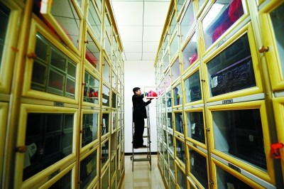 ▲魏童从骨灰寄存柜中取出骨灰。八宝山殡仪馆提供骨灰免费寄存服务,很多逝者火化后的骨灰并不马上取走,数百个寄存柜成为逝者暂时的安置所。 ▲魏童从骨灰寄存柜中取出骨灰。八宝山殡仪馆提供骨灰免费寄存服务,很多逝者火化后的骨灰并不马上取走,数百个寄存柜成为逝者暂时的安置所。