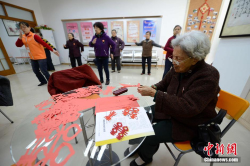 图为93岁的萨可丁老人在社区居家养老站里剪纸。 王东明 摄