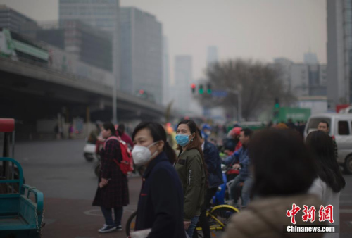 资料图:3月20日,北京市民在雾霾中出行。中新社记者 刘关关 摄 资料图:3月20日,北京市民在雾霾中出行。中新社记者 刘关关 摄