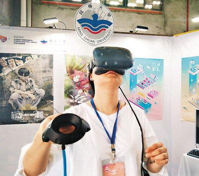 图为活动中一名女同学头戴学生自制的VR设备体验虚拟现实场景。 徐 林摄
