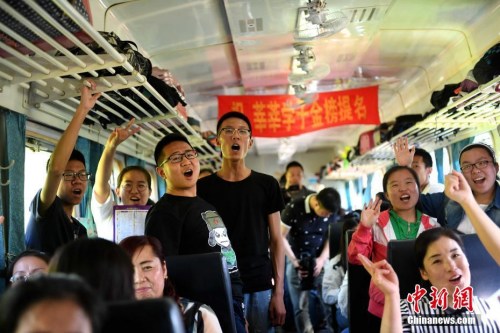 资料图：2017年6月5日，乘坐“高考专列”的学生在车厢内集体加油助威。中新社记者 王舒 摄