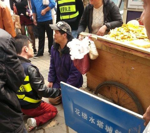 小贩车被扣下跪求情 城管为防误会与其“对跪”