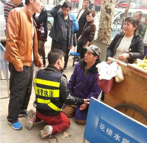 小贩车被扣下跪求情 城管为防误会与其“对跪”