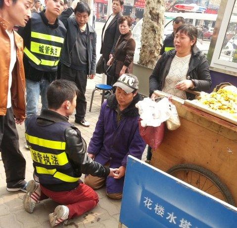 小贩车被扣下跪求情 城管为防误会与其“对跪”