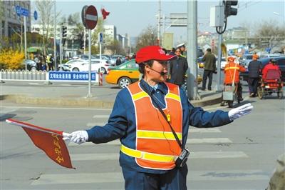 北京市交通协管员增配喊话器引导行人过马路