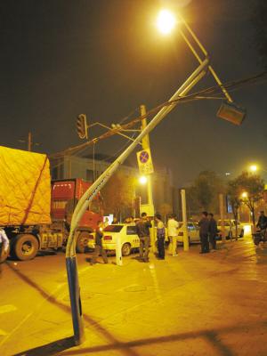 20多米长大货车超高闯祸 拉断电线杆砸坏信号灯