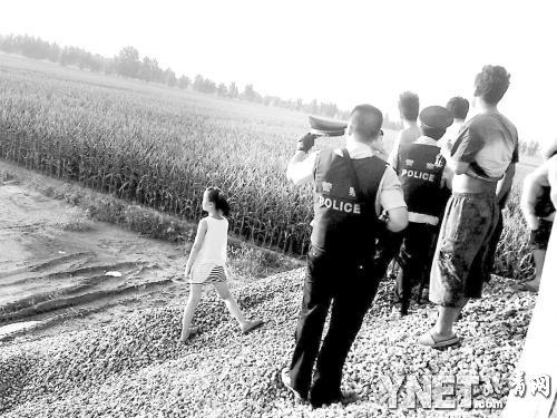 警察在事发地附近的玉米田边围堵