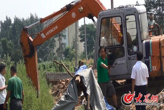 陈宝成手持自制刀斧守在挖掘机旁阻止便衣民警靠前。(视频截图)