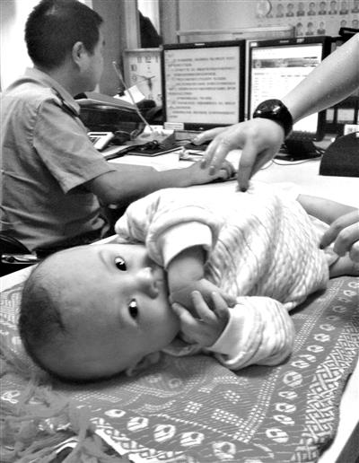 昨日,遗弃在奥迪车内的男婴,被送往派出所。 新京报记者 李宁 摄