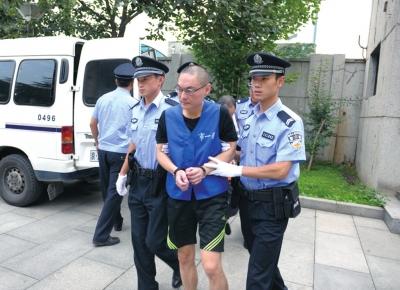 韩磊被法警押下警车。
