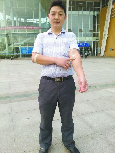 昨日到武汉血液中心献血后,罗欲平准备乘车回阳逻,手臂上还留有止血胶布。 记者王刚 摄