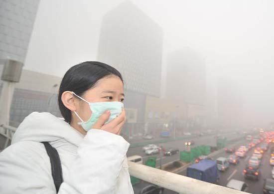 重污染天来袭,一名行人戴口罩通过人行天桥. 资料图片