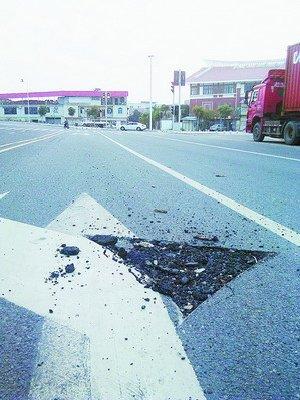 巨石从行驶大车上滚落 将路面砸出几个坑(图)