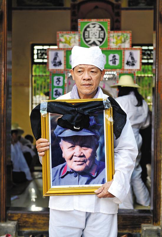 今天上午举行的追思仪式上,老人的儿子翁祚雄手捧遗像 羊城晚报记者