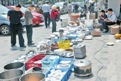 满庭芳酒楼的工作人员甩卖餐具。