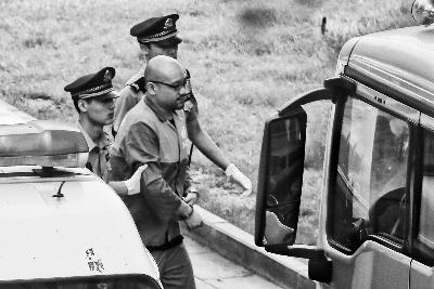 上午8时30分,穿着号服的李代沫被两名法警带下警车摄/法制晚报