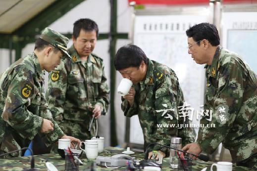 武警云南总队司令员王诚在抗震指挥部尝通过"单兵净水器"过滤后的