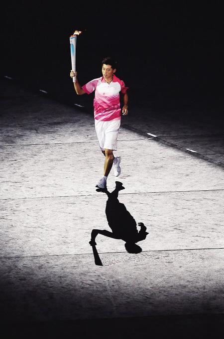 图为火炬手,著名乒乓球运动员张继科在开幕式上传递圣火.