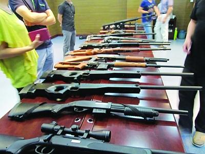 警方缴获的各式各样仿真长短枪,部分枪上配有瞄准镜和红外线.