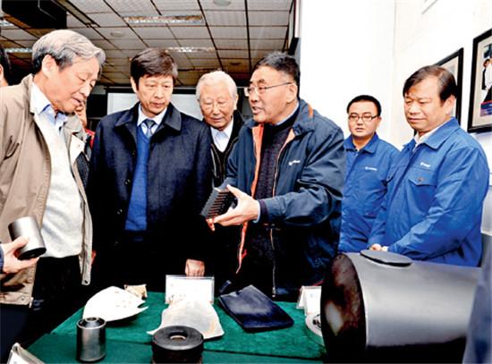 p52-1 初长祥(右三)向行业专家介绍柳工自主研发的减振降噪产品