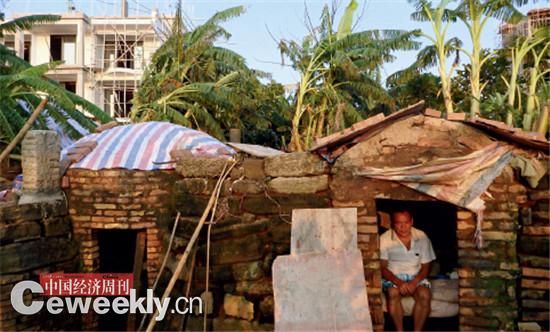 p36 黄国才在地堡里坐着,左边是鸡圈,后面的香蕉地里,是正在进行的违建房。他在这里住了10年,面朝大海,但一直等不到春暖花开。《中国经济周刊》记者 郭芳 摄