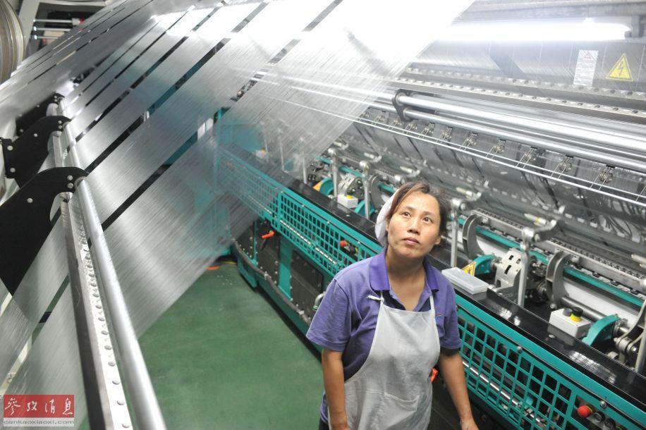 资料图片:6月26日,莆田华峰集团员工谭双利查看制造鞋服面料的高智能