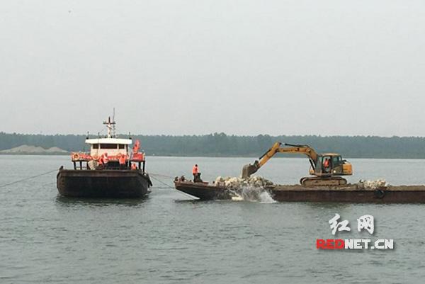 ͼΪ������Ա�ں�ˮ�۱��������Ӷ���Ͷʯ�顣