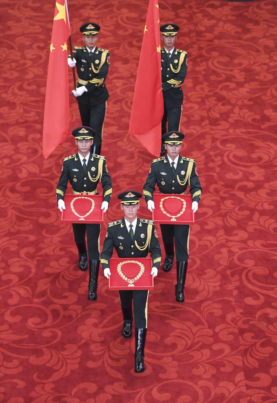 仪式号角奏响,2名护旗手高擎五星红旗,3名礼兵手捧共和国勋章,友谊