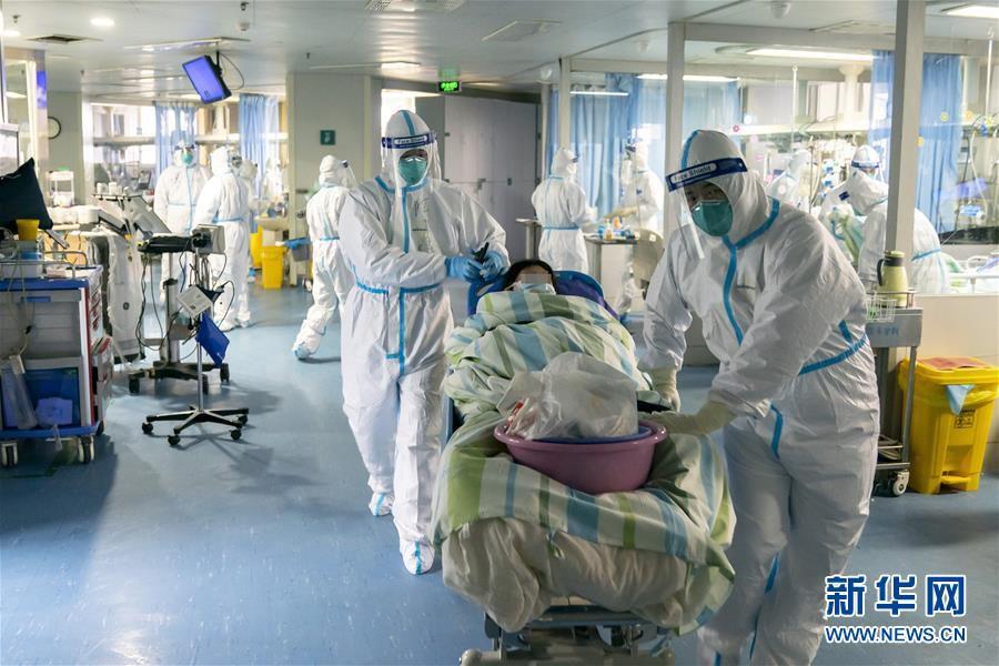 1月24日,武汉大学中南医院重症隔离病房的医护人员将一名好转的病人