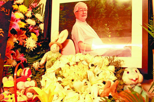 在华老的遗像前摆着许多玩具小兔子.