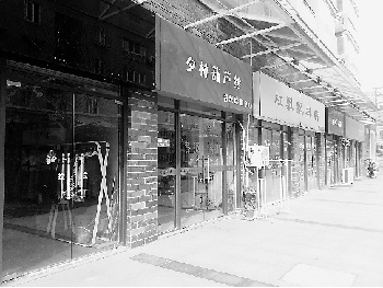 金沙学府小区商业街西街生意冷清,大多店铺"铁将军"把门.