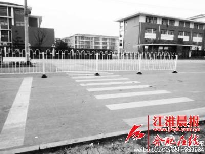 学校门口斑马线被隔离栏隔断行人过马路要“跨栏”