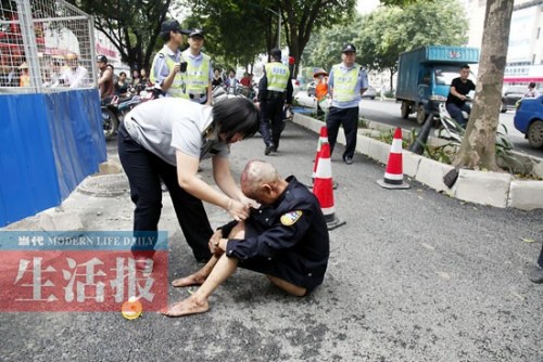 男子上身赤裸浑身是血坐路边女城管脱制服帮其穿上