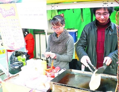 涂勇和女友小唐在做手抓饼.朱建华 摄