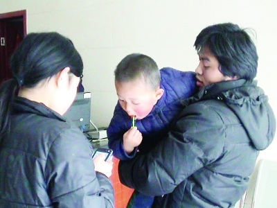 刘女士抱着自己的儿子.肖雷 摄