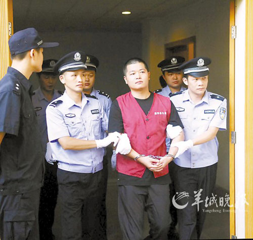 法警将胡益华带入法庭  黄巍俊 摄