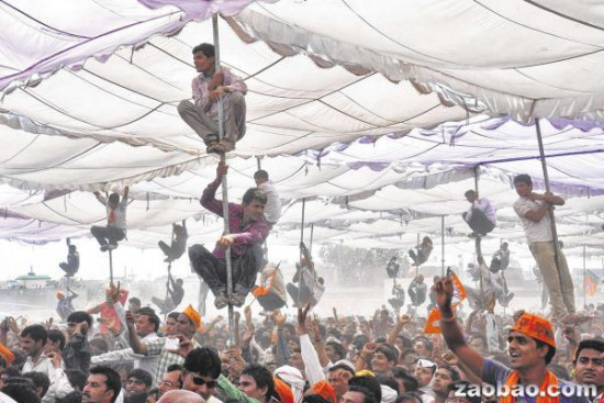 为一睹偶像风采印度铁杆选民冒险爬杆眺望(图)
