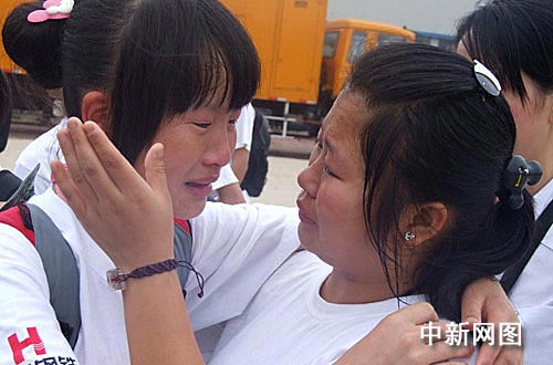 图为临别时孩子们与朝夕相处的老师依依不舍.