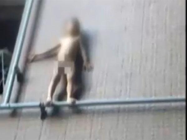 男童翻出阳台 煤气管上走钢丝