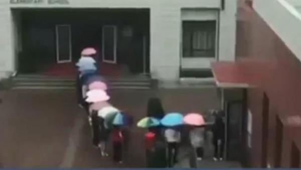 天降倾盆大雨 老师排队搭起伞廊